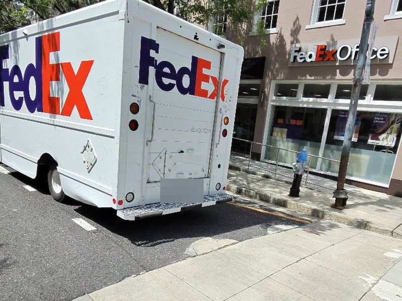 A delivery truck parked into the corner beside a fire hydrant in New Orleans